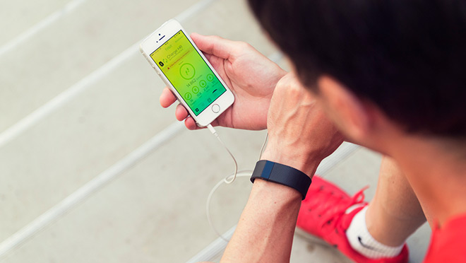 Image of a man viewing Fitbit app on a mobile phone after a run Image of a man viewing Fitbit app on a mobile phone after a run