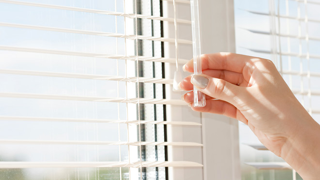 Image of hand closing venetian blinds Image of hand closing venetian blinds
