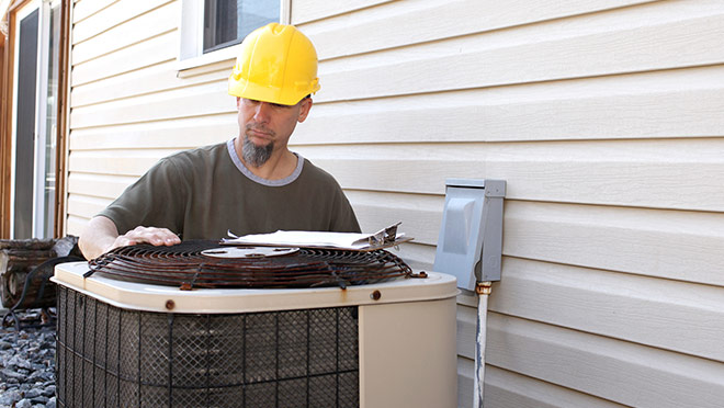 HVAC contractor repairs a residential air conditioner