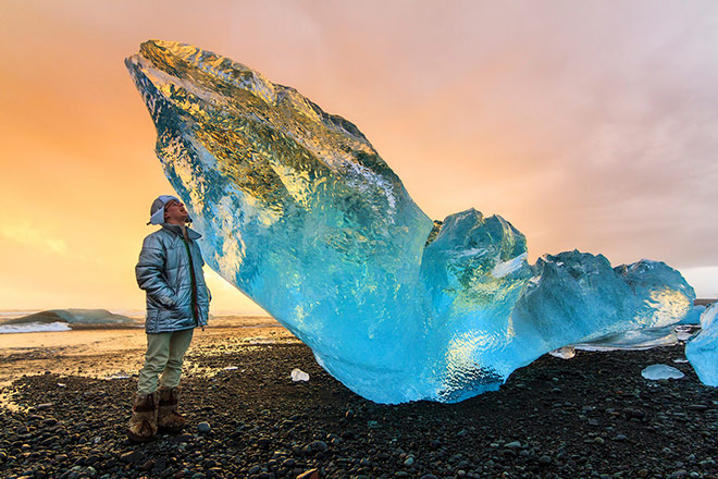 Image of tourist and beached ice chunk in Iceland Image of tourist and beached ice chunk in Iceland