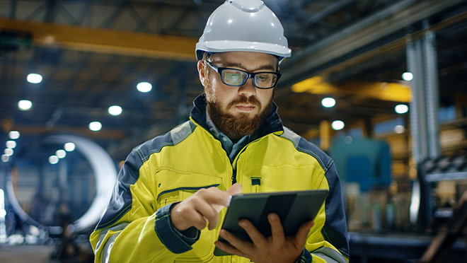 Image of a worker performing an inspection while carrying a tablet computer