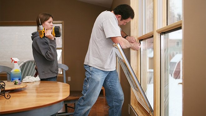 Image of a man and woman installing energy-efficient windows