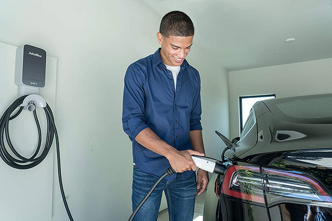 Man plugging Tesla EV into a JuiceBox EV charger