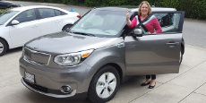 Woman standing by an electric vehicle