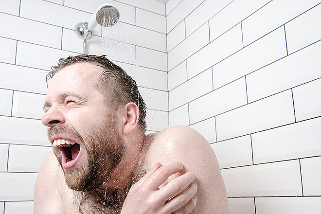 Bearded man taking a cold shower