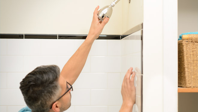 Man installing a water saving showerhead Man installing a water saving showerhead