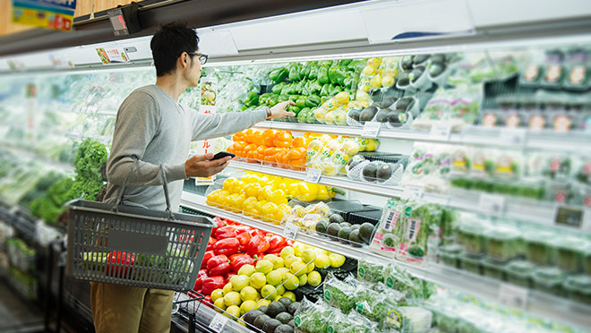 Image of man grocery shopping and carrying smart phone Image of man grocery shopping and carrying smart phone