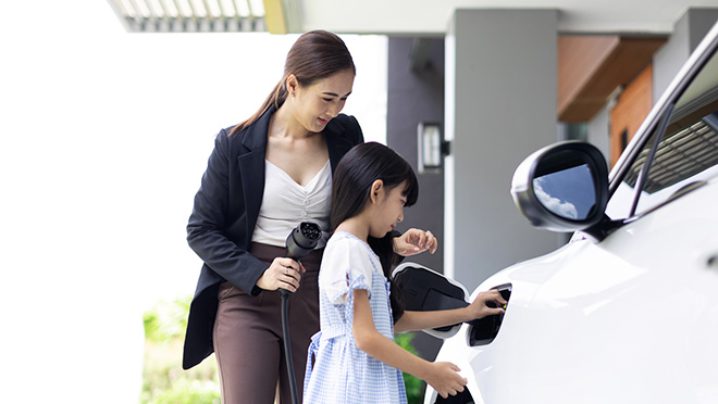 Mother and child plugging in an EV for charging