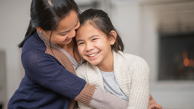 Smiling mother and daughter embracing