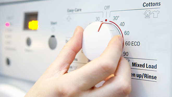 Image of a person setting the temperature on a washing machine
