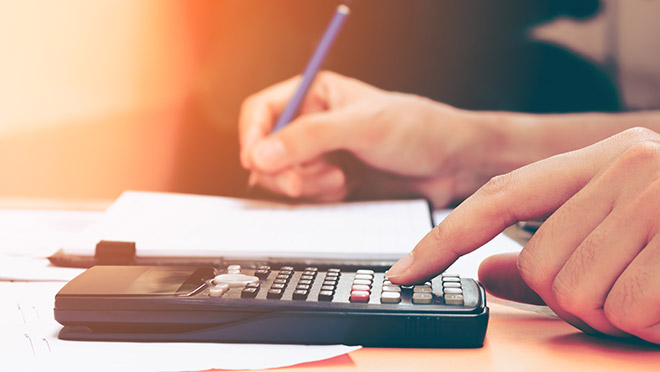 Image of an office worker using a desktop calculator Image of an office worker using a desktop calculator