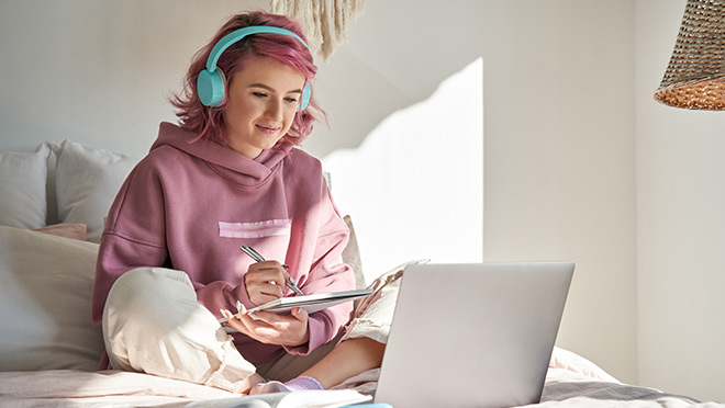 Girl with pink hair using laptop computer