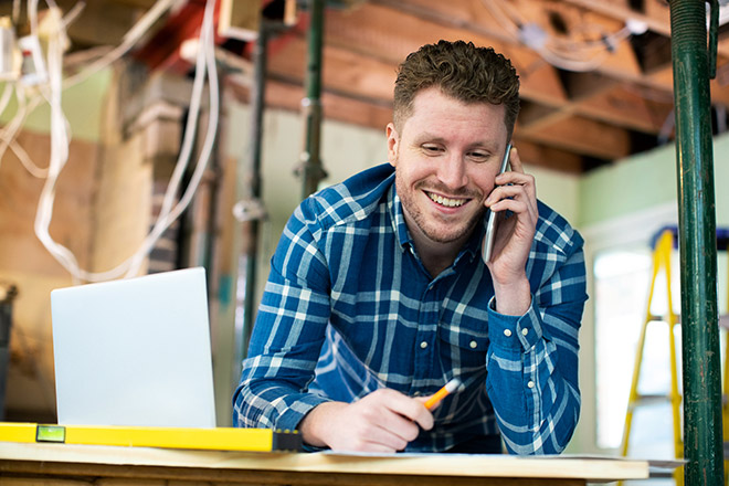 Smiling man on phone in space under renovation