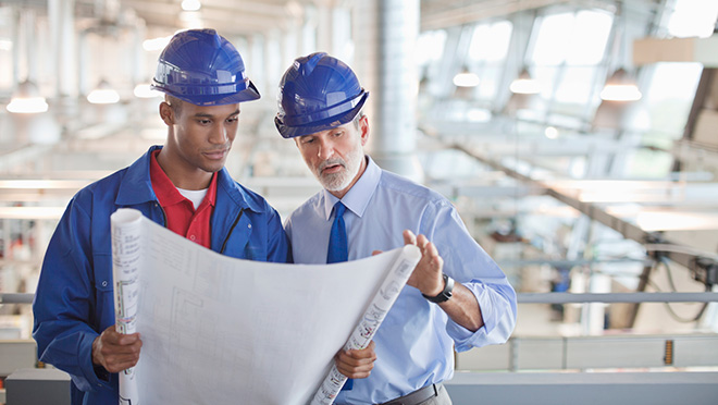 Plant workers review technical drawings