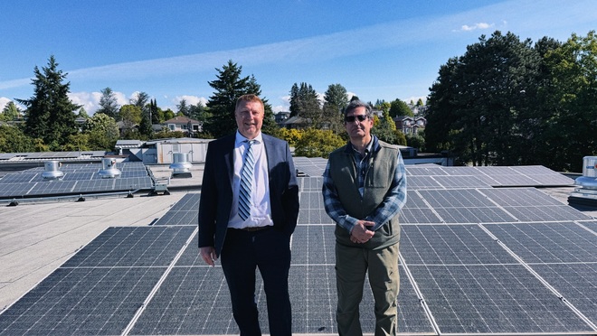 Tony Munster (left) and Mehrdad Gharibnavaz of Providence Health Care stand on the roof of Vancouver's Holy Family  Hospital, where a second phase of solar panels is expected to boost annual solar generation at the hospital to 273 GWh.