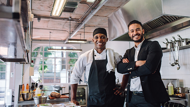 Smiling restaurant workers in a commercial kitchen