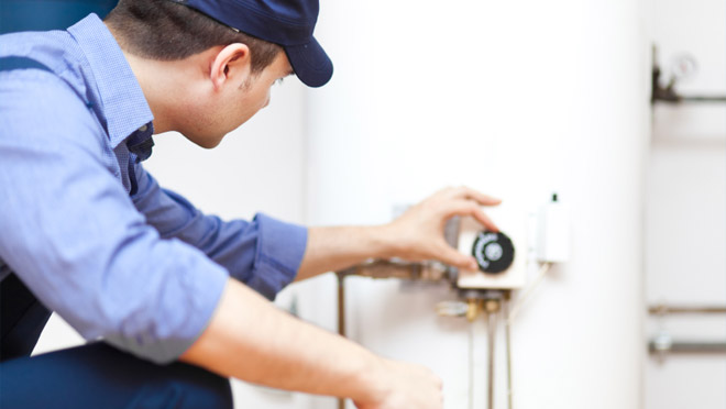 hot water heater adjustment man checks hot water heater temperature
