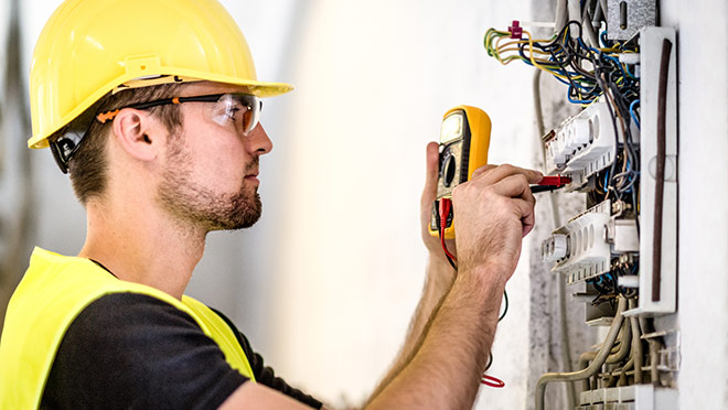 Image of an electrician testing with a multimeter Image of an electrician testing with a multimeter
