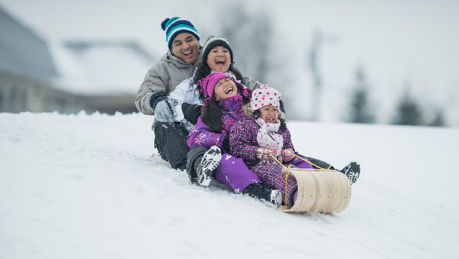 A happy family tobogganing