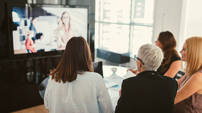 Image of employees watching a webinar together