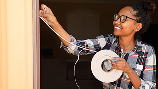 Woman installing weatherstripping Woman installing weatherstripping