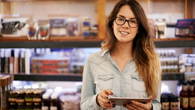 Image of a woman reading on a tablet computer in a shop Image of a woman reading on a tablet computer in a shop