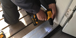 Construction worker uses cordless drill doing renovation work at home.