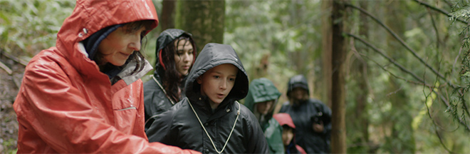 A group of hikers wearing rain gear in the forest A group of hikers wearing rain gear in the forest