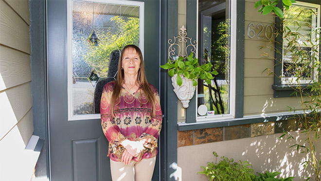 A woman who invested in a heat pump for her home in Langford Disa Hovatta at the front door of her Langford, B.C. home