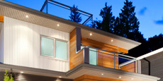 A modern multi-story house set against a twilight sky.