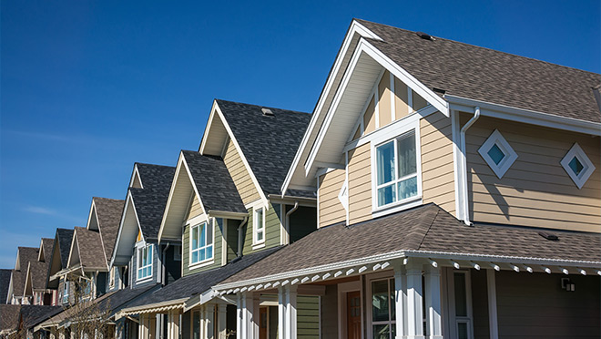 Modern suburban row houses under a clear blue sky