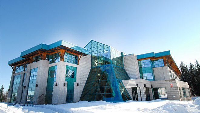 Image of a modern building on the UNBC campus surrounded by winter snow