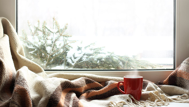 Image of a steamy coffee mug inside a cozy home