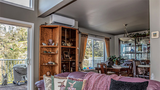 Heat pump above bookcase on main floor of home Heat pump above shelving unit on main floor of home
