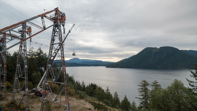 Detonation specialists work with a BC Hydro power line technician to secure the detonation device on the third and final conductor. 