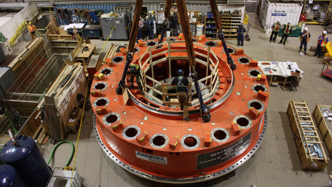 Mica generator cap on sling Generator cap for Mica unit No. 6 shows workers and crane sling during installation in May 2015