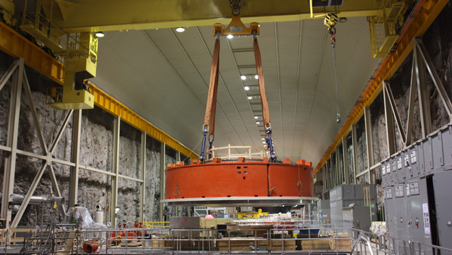 Mica generator 6 cap on crane Crane in Mica powerhouse carries generator No. 6 cap to its place above turbine
