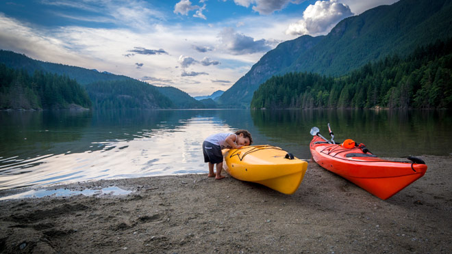 Image of young boy with kayaks at Buntzen Lake Image of young boy with kayaks at Buntzen Lake