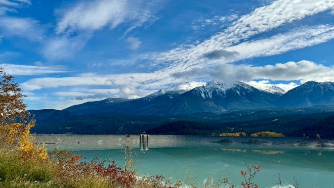 La Joie Dam with mountains and blue sky with some clouds.
