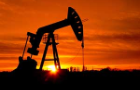 Pump jack in an oil field at sunset