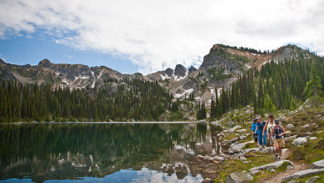 Mount Revelstoke hike at lake Hikers walk the short of an alpine lake in Mount Revelstoke National Park.
