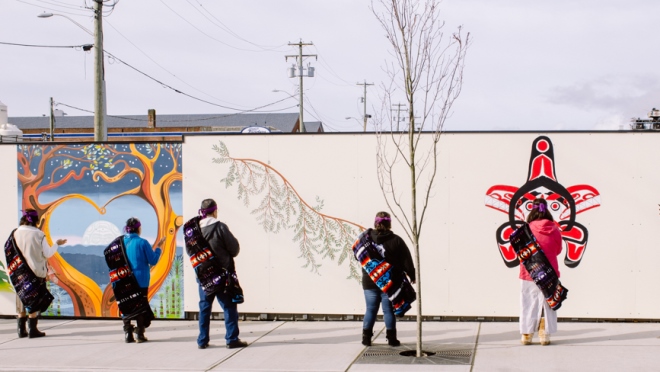 Wide shot of five First Nations Members in front of new Rock Bay murals