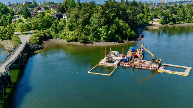 Floating construction barge carrying heavy equipment.