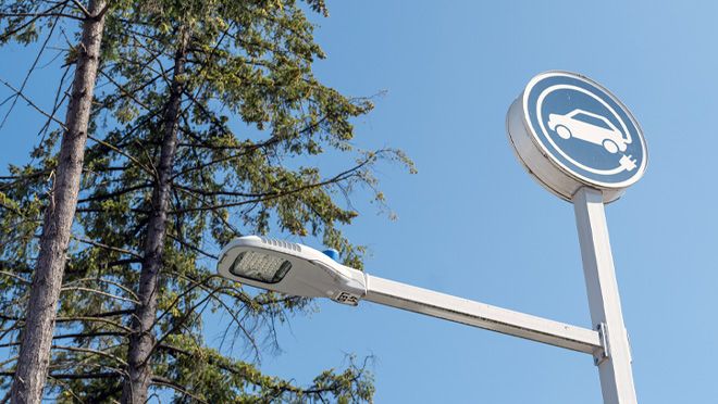Electric vehicle charging station sign with streetlight at Canadian Superstore Coquitlam.