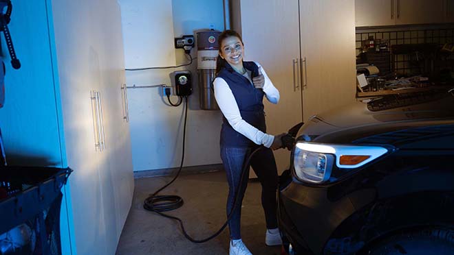 Jaclyn charging an EV vehicle at night
