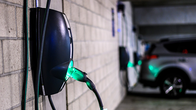 Image of an illuminated EV charger in a parking garage