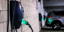 Image of an illuminated EV charger in a parking garage