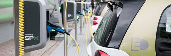 A row of electric vehicles plugged in A row of electric vehicles plugged in