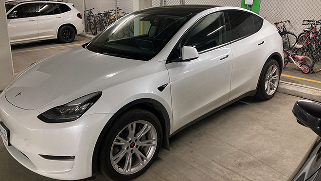 A Tesla EV charging in a downtown Vancouver condo tower