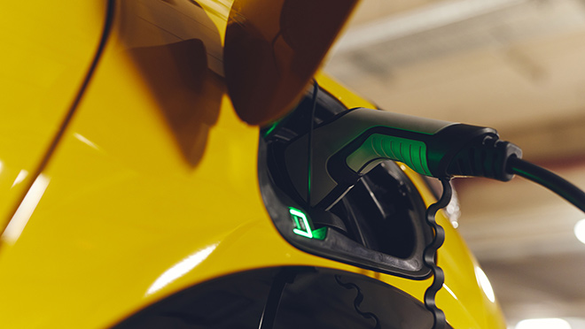 Yellow EV connected to charger Yellow EV connected to charger